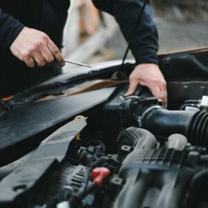 Taller Mecánico Málaga Arenas. A mechanic working on a car engine with tools, focused on repairs.